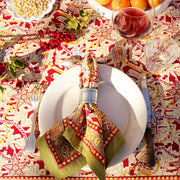 Couleur Nature - Noel Red & Green tablecloth elegantly set with festive dinnerware, showcasing handprinted holiday patterns and traditional French design.