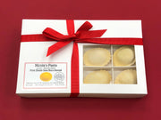 Nicola's Marketplace - Pork Osso Buco Ravioli in a gift box with a red ribbon, featuring four visible handmade pasta parcels through a clear window.