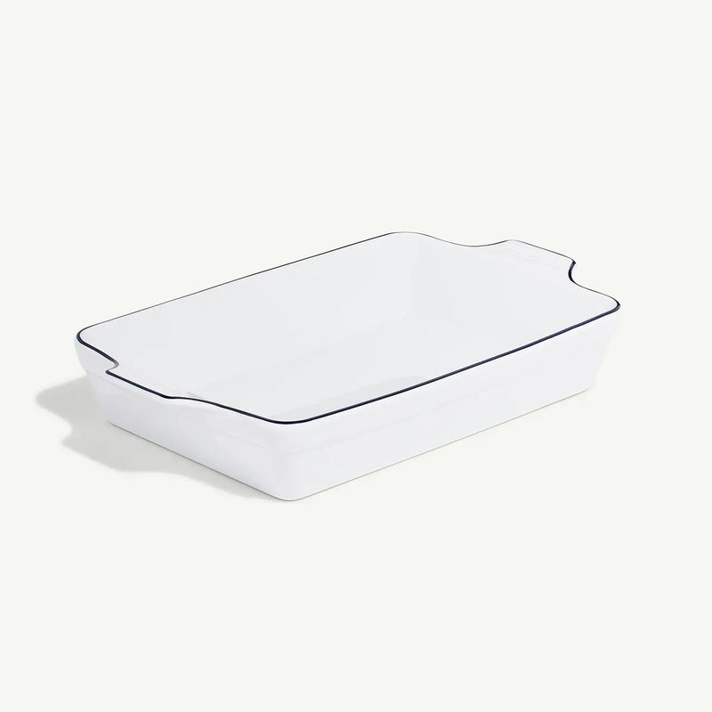 Made In | Rectangular Baking Dish, Navy Rim features a sleek, glossy white finish with flared sides and built-in handles for effortless handling.