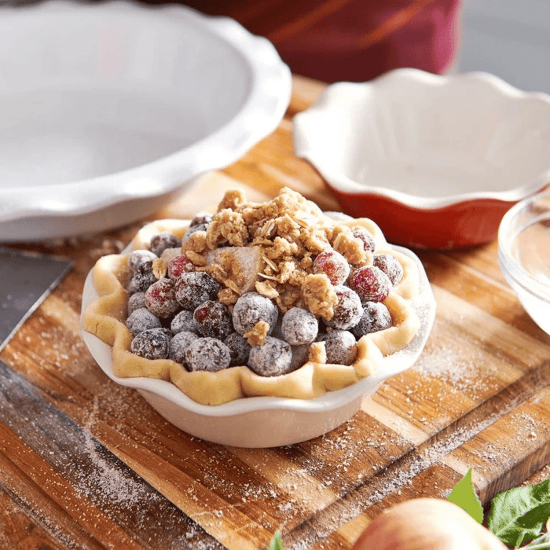 Emile Henry | Modern Classics Mini Pie Dish with unbaked berry tart, featuring crimped edges and streusel topping, on a floured board, highlighting expert pie-baking craftsmanship.