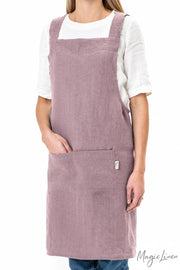 Person wearing MagicLinen's pinafore cross-back linen apron with a front pocket, perfect for cooking and gardening, offered by Athens Cooks kitchen store.