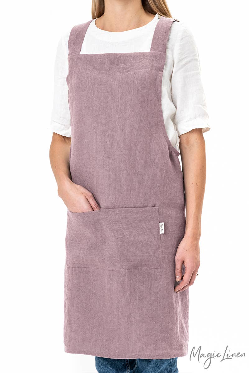 Person wearing MagicLinen's pinafore cross-back linen apron with a front pocket, perfect for cooking and gardening, offered by Athens Cooks kitchen store.