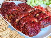 Southern Roots Sisters - Raspberry Chipotle Jam is showcased as a glaze on meatloaf, paired with crackers and grapes, highlighting its versatility for various dishes.