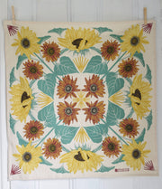 Hearth and Harrow - Sunflower Tea Towel - Organic Cotton - Oversized 30 x 30, featuring a sunflower pattern with teal leaves, hung with clothespins.