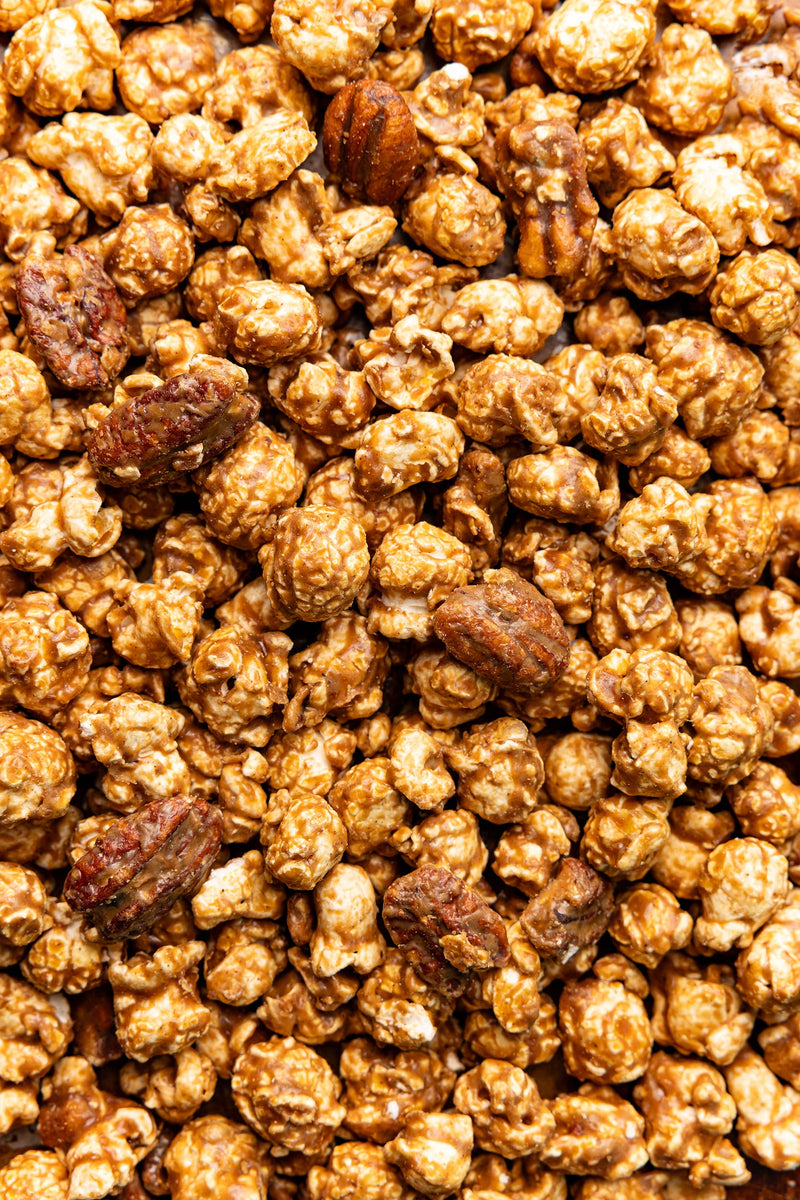 Poppy Hand-Crafted Popcorn - Cinnamon Bourbon Pecan Popcorn features caramel-coated popcorn with praline pecans, offering a Southern-inspired, gluten-free snack experience.