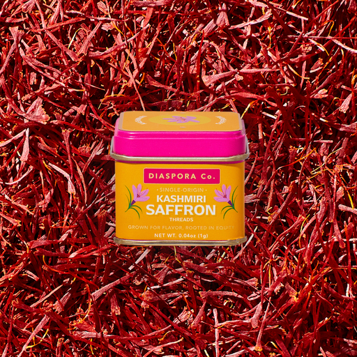 Diaspora Spices Co. - Kashmiri Saffron (Grade A Threads), single-origin spice tin surrounded by loose saffron strands, showcasing premium quality from Pampore's historic saffron district.