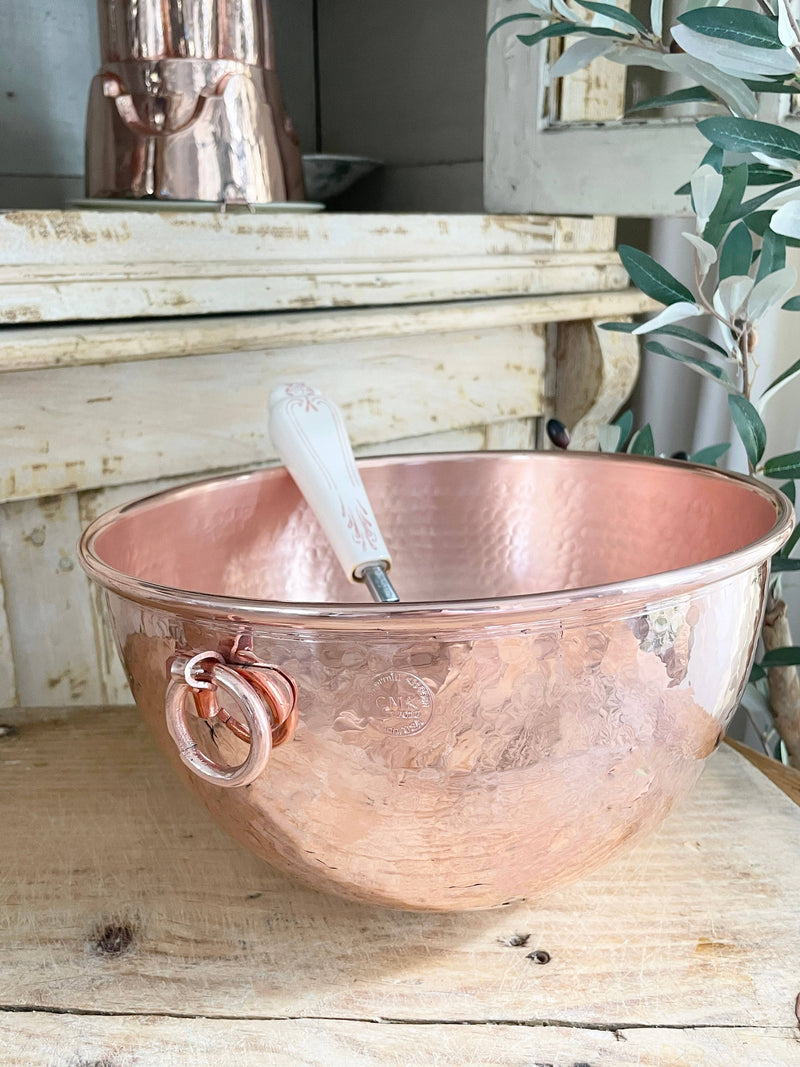 Coppermill Kitchen LLC - Coppermill Vintage Inspired Mixing Bowl with loop handles and a white-handled utensil, exuding rustic elegance on a wooden surface.