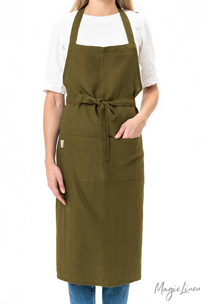 Woman wearing MagicLinen - Charcoal Grey Linen Bib Apron with Pockets, showcasing its stylish and functional design, perfect for cooking and gardening activities.