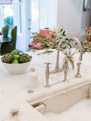 L'AVANT Collective - Fresh Linen High Performing Dish Soap in a matte white bottle beside a sink with fruit, enhancing kitchen elegance.