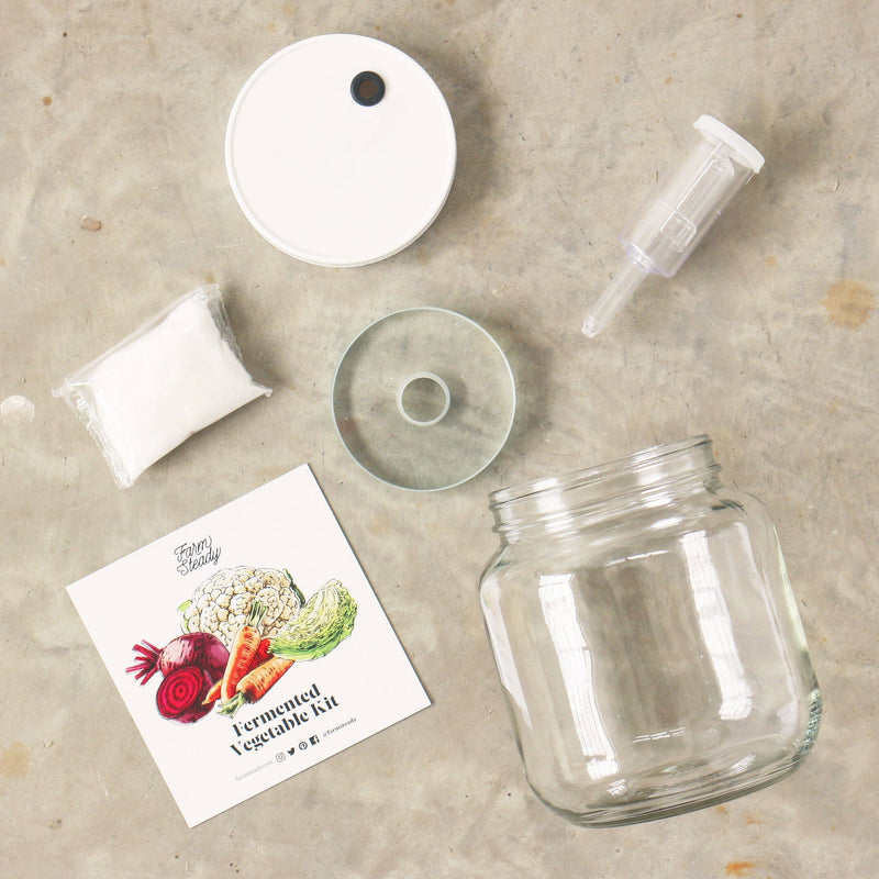 FarmSteady - Fermented Vegetable Kit featuring a glass fermenting jar with lid, airlock, and fermentation weight on a table. Perfect for healthy lacto-fermenting vegetables.