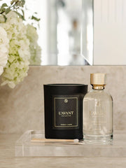 L'AVANT Collective - Fresh Linen Room Spray 100 ml with a candle on a counter, enhancing your home ambiance with elegant fragrance.