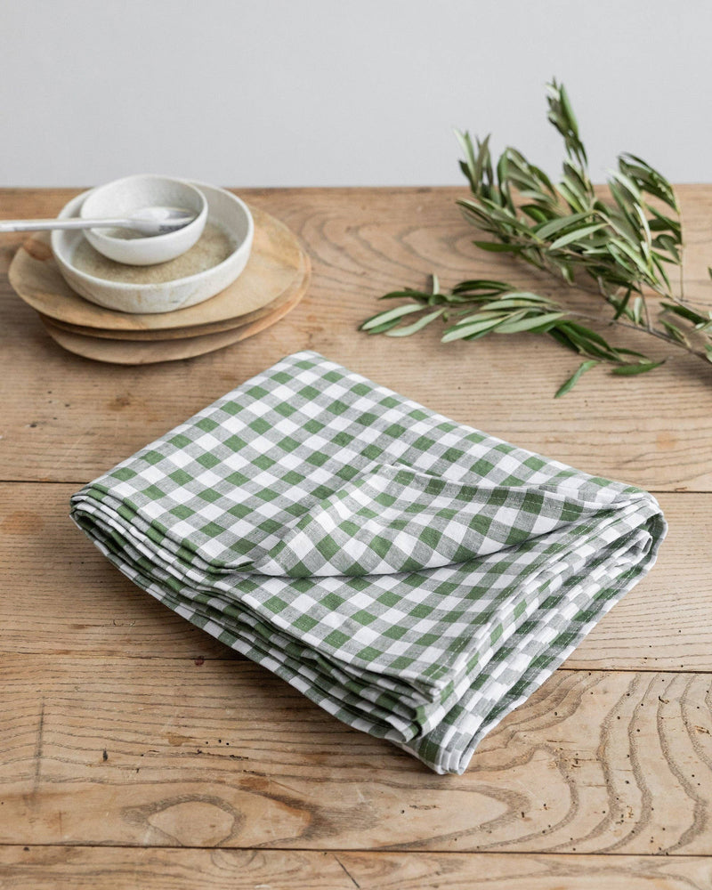 MagicLinen - Linen tablecloth in Forest green gingham, 59x59, displayed with a bowl and spoon, enhancing dining elegance and style.