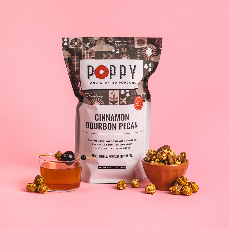Poppy Hand-Crafted Popcorn - Cinnamon Bourbon Pecan flavor, featured with a garnished bourbon drink and a bowl of popcorn, embodies Southern-inspired gourmet snacking.