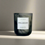 Slow North - Spellbound - Limited Edition Halloween Candle in a smoky glass, featuring tangerine, ginger, and cinnamon scents with a seed paper cover for planting.