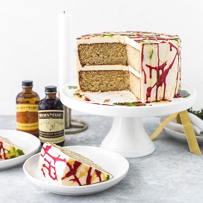 Nielsen-Massey Pure Almond Extract bottle beside a cake slice on a plate, ideal for enhancing baked goods.