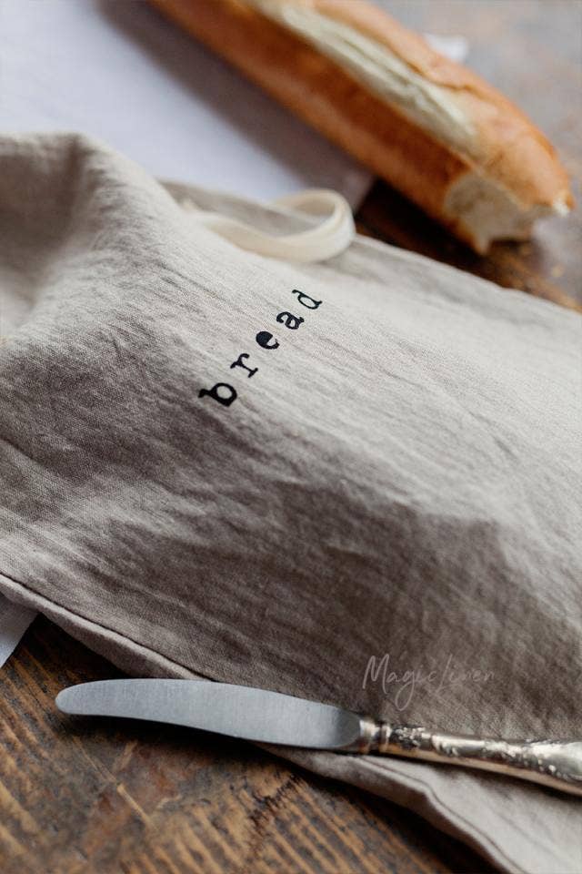 MagicLinen - Printed linen bread bag with bread logo, alongside a knife and loaf, perfect for keeping bread fresh, sold at Athens Cooks kitchen store.