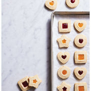 Assorted jam-filled shortbread cookies showcase the HIC - Harold Import Co. - King Arthur Thumbprint Cookie Cutters 4-Piece Set on a parchment-lined baking sheet.