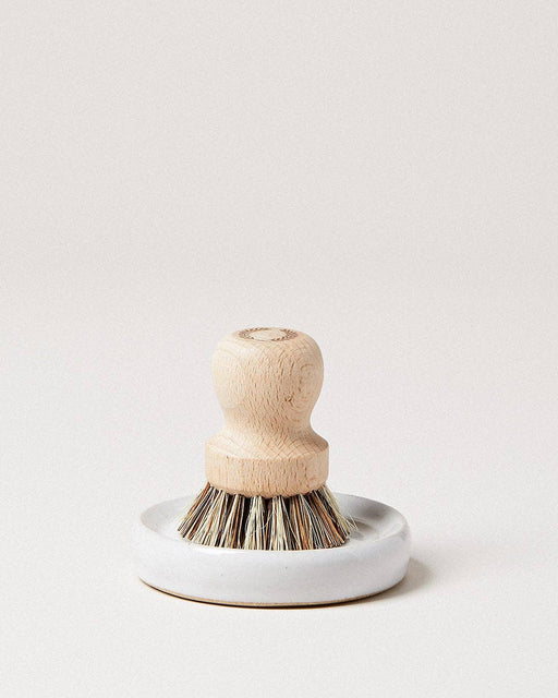 Farmhouse Pottery - Laurel Pot Brush Set: A hand-held scrub brush with a wooden handle and natural bristles, in a white ceramic dish, ideal for organized kitchen cleaning.