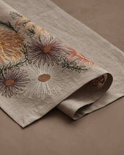 Coral & Tusk - Autumn Blossoms Dinner Napkin: Beige fabric with embroidered daisies, mums, and sunflowers, ideal for enhancing fall-themed dining experiences. Measures 20 × 20.