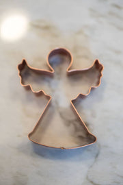 Galley and Fen - Christmas Cookie Cutters - Set of 6 featuring an angel-shaped copper cutter on marble, ideal for festive baking and decorating.