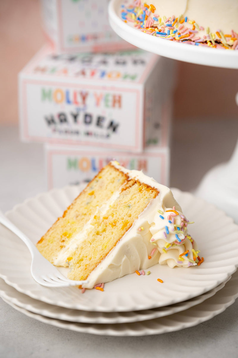 Hayden Flour Mills - Molly Yeh x HFM Confetti Cake Mix slice on a fluted plate, showcasing colorful sprinkles, perfect for celebratory baking with high-quality ingredients.