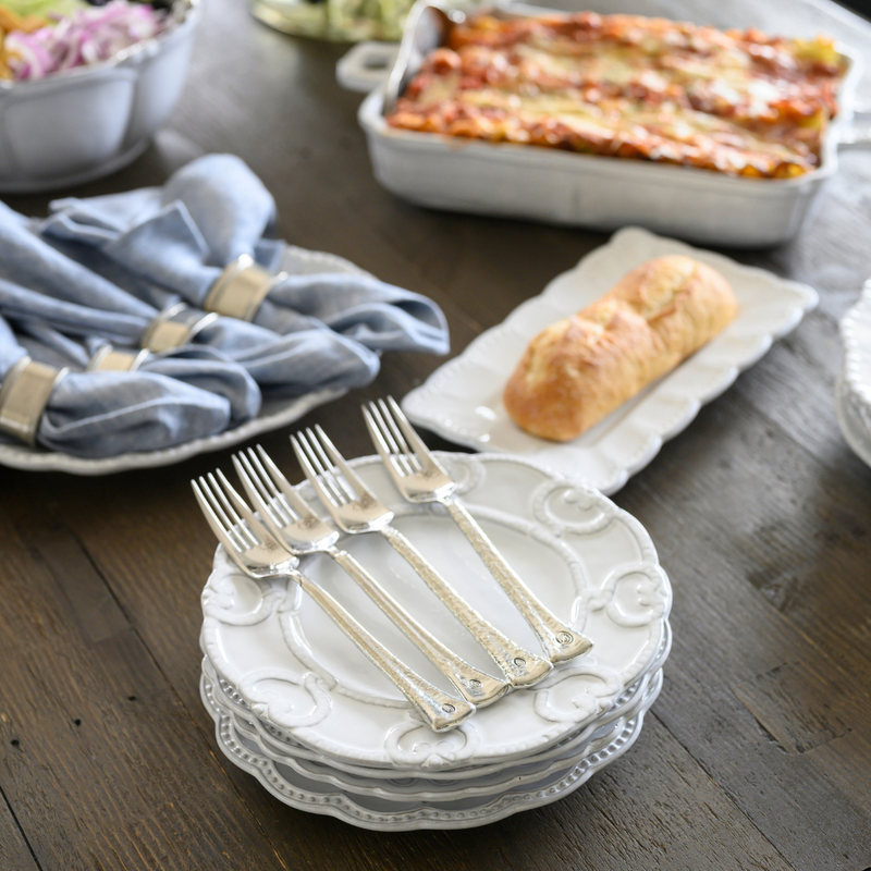 Bella Bianca Antique Lace Salad/Dessert Plate on a table set with silverware and a loaf of bread, showcasing elegant Italian stoneware design.