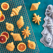 Nordic Ware | Vintage Ornament Cakelet Pan displayed with cookies and orange slices, illustrating its use for festive, detailed holiday baking creations.