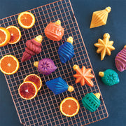 Nordic Ware | Vintage Ornament Cakelet Pan featuring colorful food arrangement, perfect for creating festive, ornament-shaped desserts with intricate details for holiday baking.