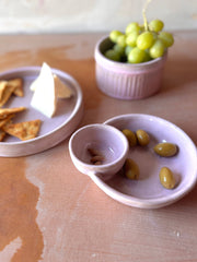 Handmade ROB Ceramics Olive Serving Bowl with attached section for pits, featuring green olives and almonds, on a wooden table with cheese and crackers nearby.