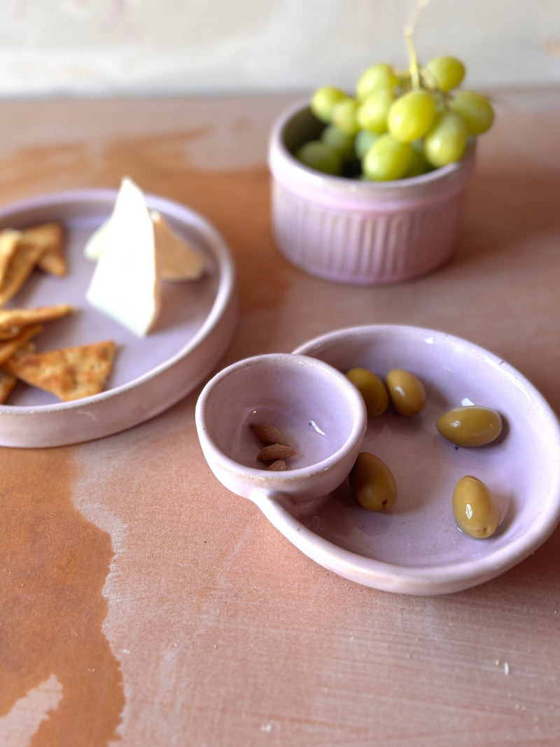 Handmade ROB Ceramics Olive Serving Bowl with attached section for pits, featuring green olives and almonds, on a wooden table with cheese and crackers nearby.