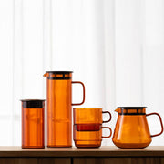 HARIO USA - HARIO Colors Glass Canister, 400ml: Amber. Amber glass canisters with black lids, showcasing elegant design and heatproof durability, perfect for stylish kitchen storage.