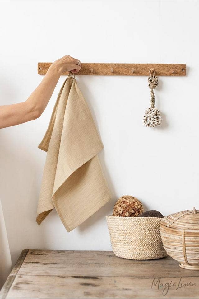 Hand holding a MagicLinen linen tea towel with a hanging loop, perfect for kitchen chores. Featured product at Athens Cooks, specializing in quality kitchen essentials.