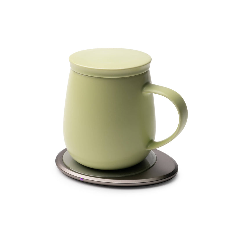 OHOM - Ui 3 Self-heating Mug Set: Jasmine White on an electronic coaster, indicating it's powered on, ideal for maintaining beverage temperature and wirelessly charging devices.