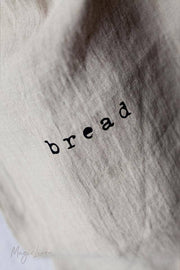 MagicLinen - Printed linen bread bag with bread screen-printed in black, designed to keep bread fresh, shown in close-up displaying the fabric texture.