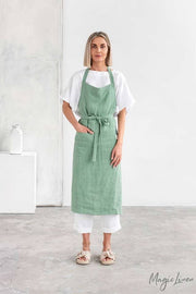 Woman wearing MagicLinen Charcoal Grey Linen Bib Apron with Pockets, ideal for cooking and gardening. Durable and stylish, enhancing culinary experiences.