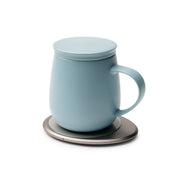 OHOM - Ui 3 Self-heating Mug Set: Jasmine White, features a light-blue ceramic mug with lid on an electric warmer, ideal for maintaining drink temperature and wireless charging.