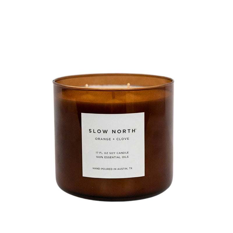 Slow North - Orange + Clove Signature 3-Wick Candle in amber glass jar, hand-poured, features warm citrus and spice aroma, ideal for cozy, inviting spaces.