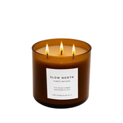 Slow North - Forest Bathing 3-Wick Soy Candle in amber jar, lit, with label detailing essential oils and hand-poured craftsmanship, perfect for creating a cozy, nature-inspired ambiance.