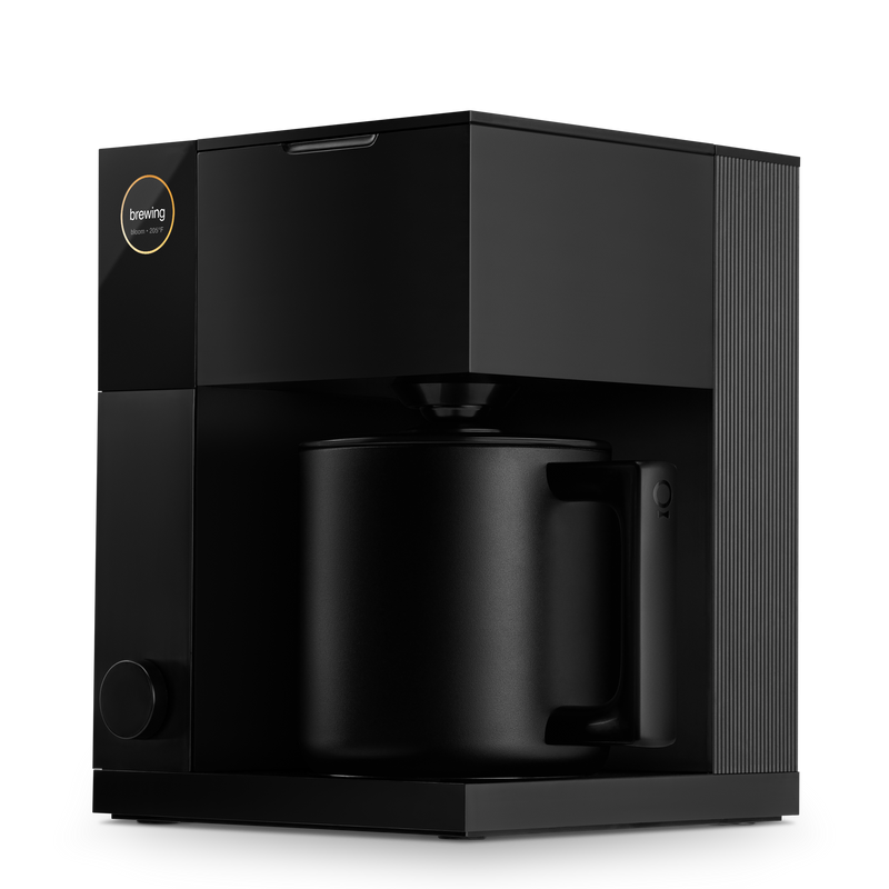 FELLOW - Aiden Precision Coffee Maker: Matte Black, displayed with a matching mug, exemplifies precise brewing for optimal coffee experience. Available for pre-order at Athens Cooks.