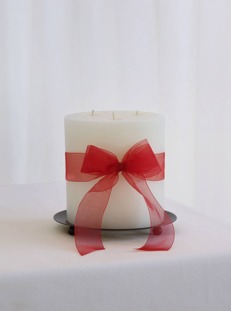 Mo&Co Home - 200h Burn | GRAND Beeswax Pillar Candle | Natural White with red ribbon on metal plate, ideal for gifting and enhancing winter evenings.