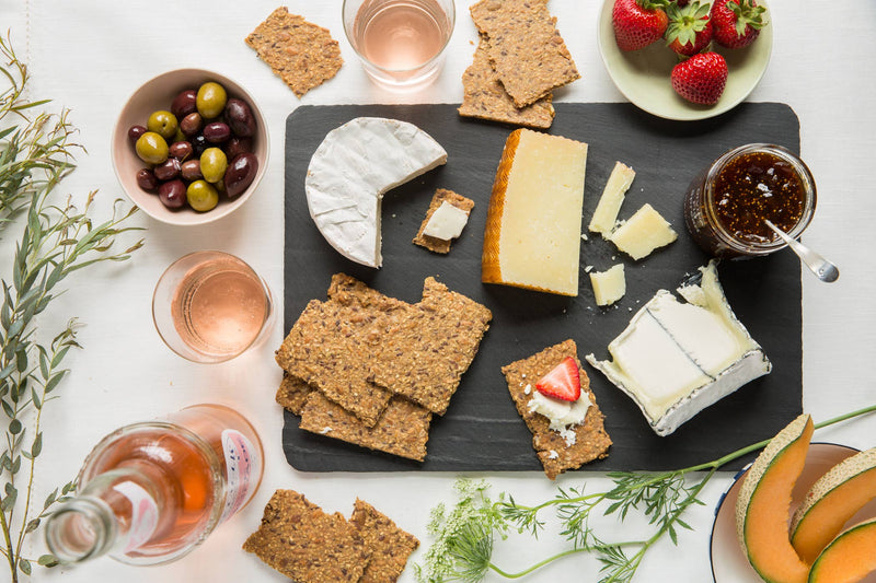 Norwegian Baked - Rosemary & Lemon Knekkebrød with cheese and fruit, highlighting a curated cheese board with Knekkebrød as a centerpiece for a gourmet experience.