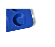 Great Jones | Stud Muffin - Blueberry: Close-up of a nonstick, nontoxic muffin pan by Athens Cooks, featuring four holes for even heat distribution and easy cleanup.
