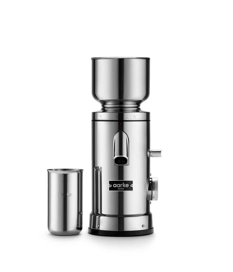 Aarke | Coffee Grinder showcased with a cup, highlighting its sleek silver design, reflecting Athens Cooks' dedication to quality kitchen appliances.
