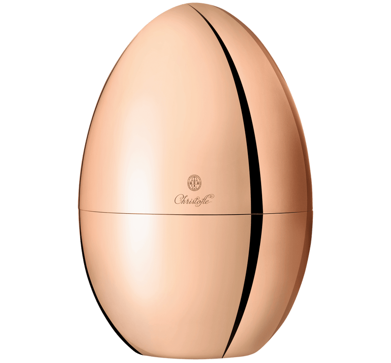Christofle | MOOD Precious 24 Pieces: A rose-gold, egg-shaped metal box by Christofle, housing a 24-piece flatware set with elegant organization inside.