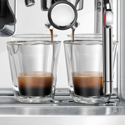 Breville | Barista Touch espresso machine pulling two shots with rich crema into glass cups, showcasing precise brewing and professional-grade features.