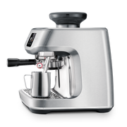 Breville | The Oracle Jet espresso machine features an integrated grinder, portafilter, and steam wand, with a milk pitcher ready for frothing.