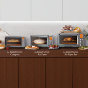 Breville | Smart Oven Air Fryer Pro showcasing a whole chicken, flanked by two other models with fries and casserole, on a modern kitchen countertop.