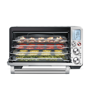 Breville | Smart Oven Air Fryer Pro with mesh trays for dehydrating produce. Digital display shows 125°F and 8:25 runtime, with temperature and time controls visible.