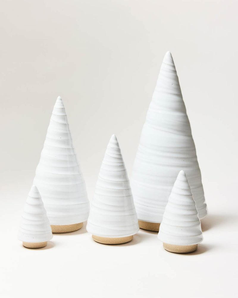 Farmhouse Pottery | Spruce Woodland Trees - Small: Five ceramic cone-shaped sculptures with white glaze tops and natural clay bases, resembling a modern forest.