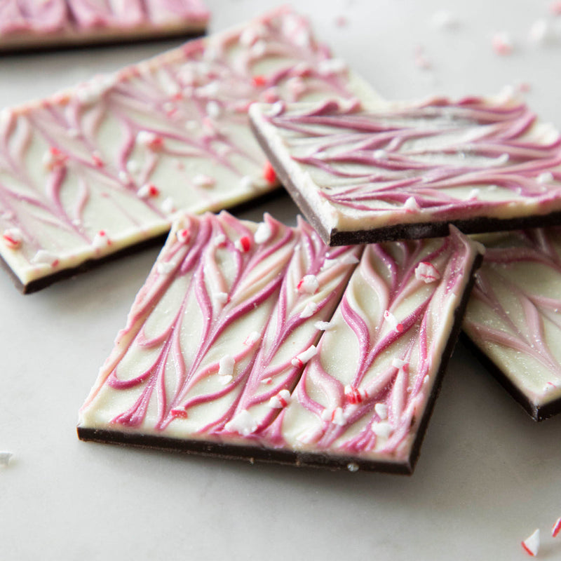 Hester & Cook | Sparkle Bark - 8 oz. features dark Belgian chocolate topped with pink swirled white chocolate, popping candy, and peppermint bits.